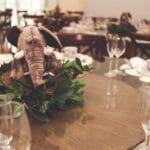 Elegancka zastawa stołowa z pluszowym słoniem wśród zielonych dekoracji