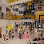 Klienci spacerują po nowoczesnej galerii handlowej pełnej butików