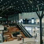 Nowoczesne, przestronne wnętrze galerii handlowej z zielenią i butikami