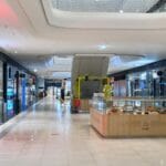 Wnętrze nowoczesnej galerii handlowej z ruchomymi schodami i sklepami