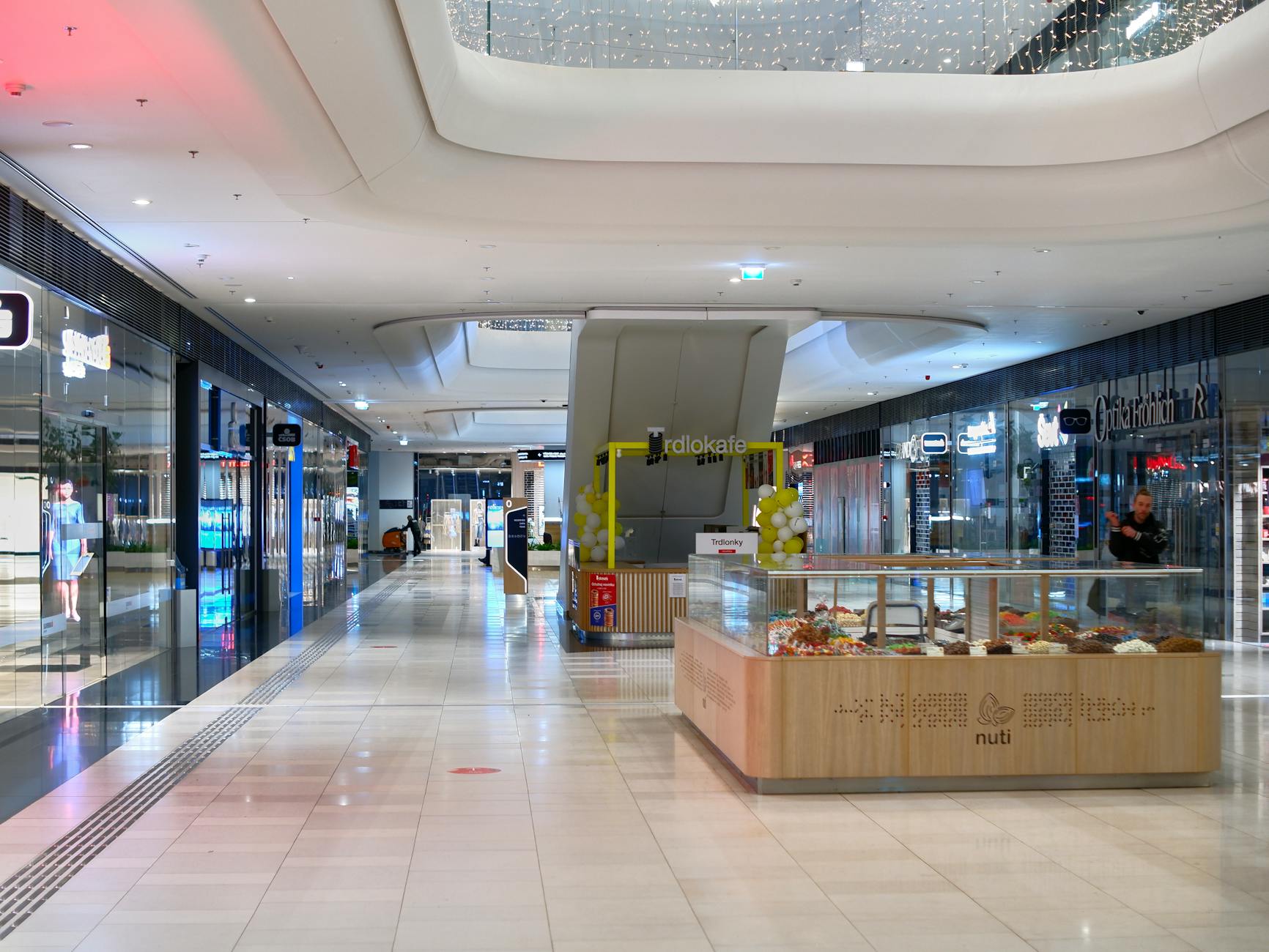 Wnętrze nowoczesnej galerii handlowej z ruchomymi schodami i sklepami