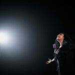 Wokalistka w dramatycznym świetle reflektora na scenie art pop