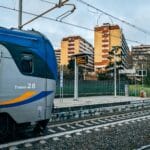 Pociąg na stacji w Rzymie na tle mieszkalnych kamienic