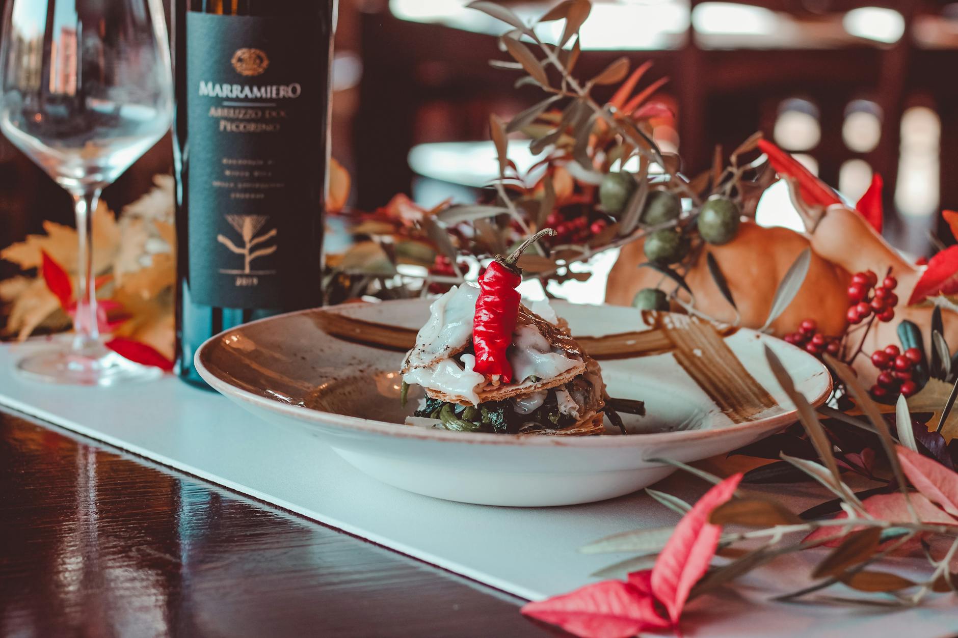 Eleganckie jesienne danie restauracyjne z kieliszkiem czerwonego wina