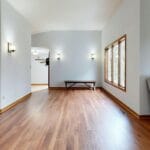 Jasny minimalistyczny salon z drewnianą podłogą i nowoczesnymi meblami