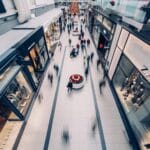 Klienci spacerują po nowoczesnej galerii handlowej podczas nocnych zakupów