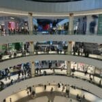 Tłum kupujących w wielopoziomowej, nowoczesnej galerii handlowej