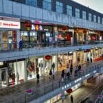 Wieczorny ruch klientów w nowoczesnej galerii handlowej