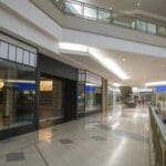 Wnętrze nowoczesnej galerii z zamkniętymi lokalami i ruchomymi schodami