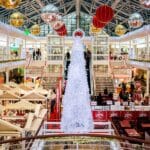Tłum przechodniów w galerii handlowej z dużą choinką świąteczną