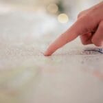 Dłoń wskazująca plan miasta i trasę dojazdu